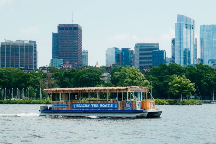 a small boat in a body of water with a city in the background